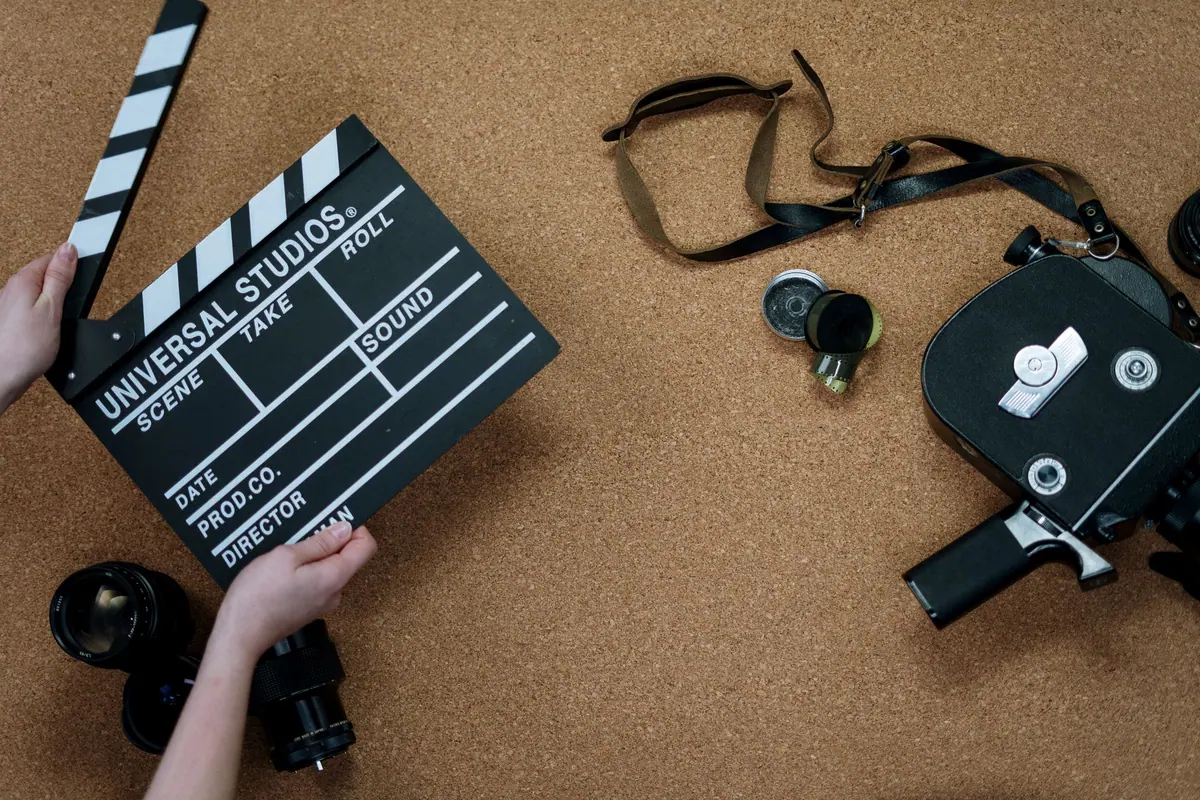 Cameră de filmat veche și un clachetă de film pe un fundal de plută, văzute de sus