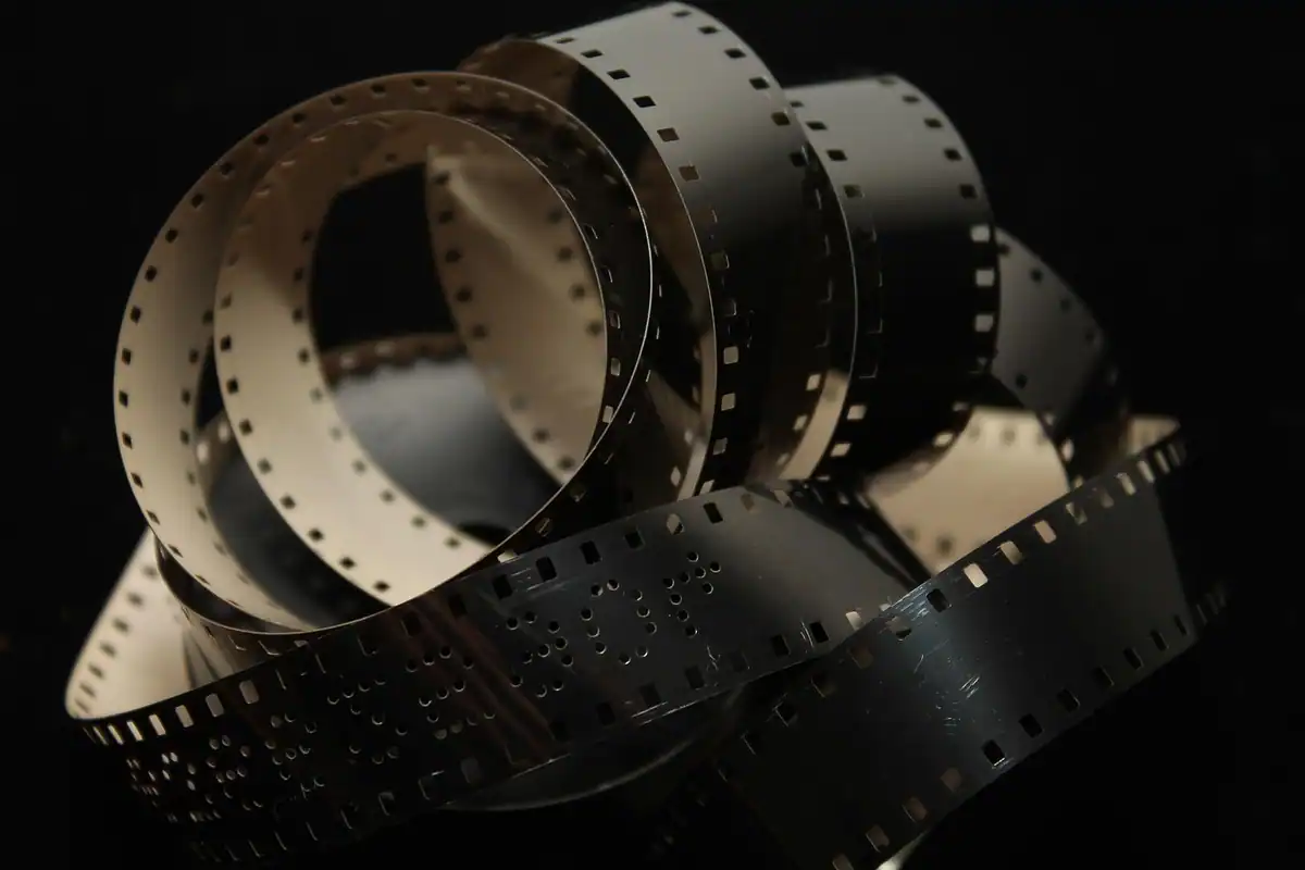 Fâșie de peliculă de film răsucită, așezată pe un fundal negru