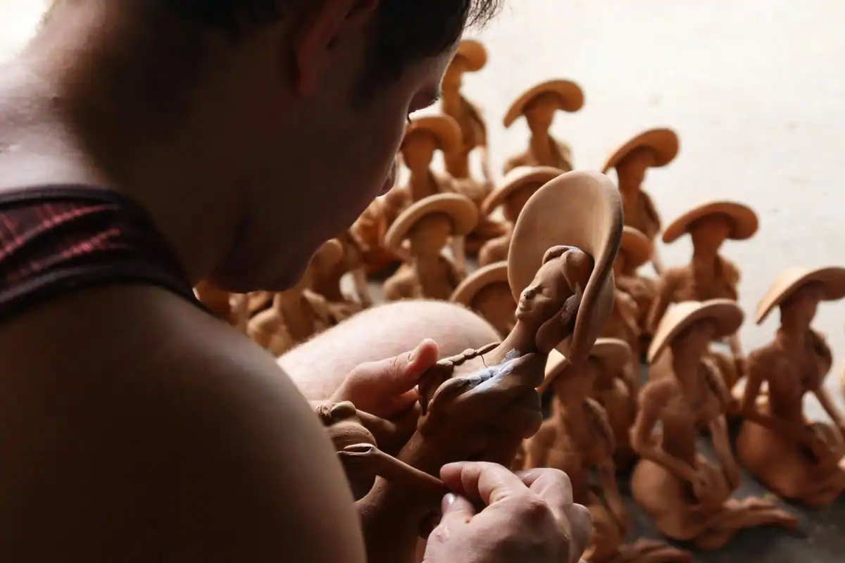 Un artist modelează cu atenție figurine din lut, pregătite pentru o animație cadru cu cadru
