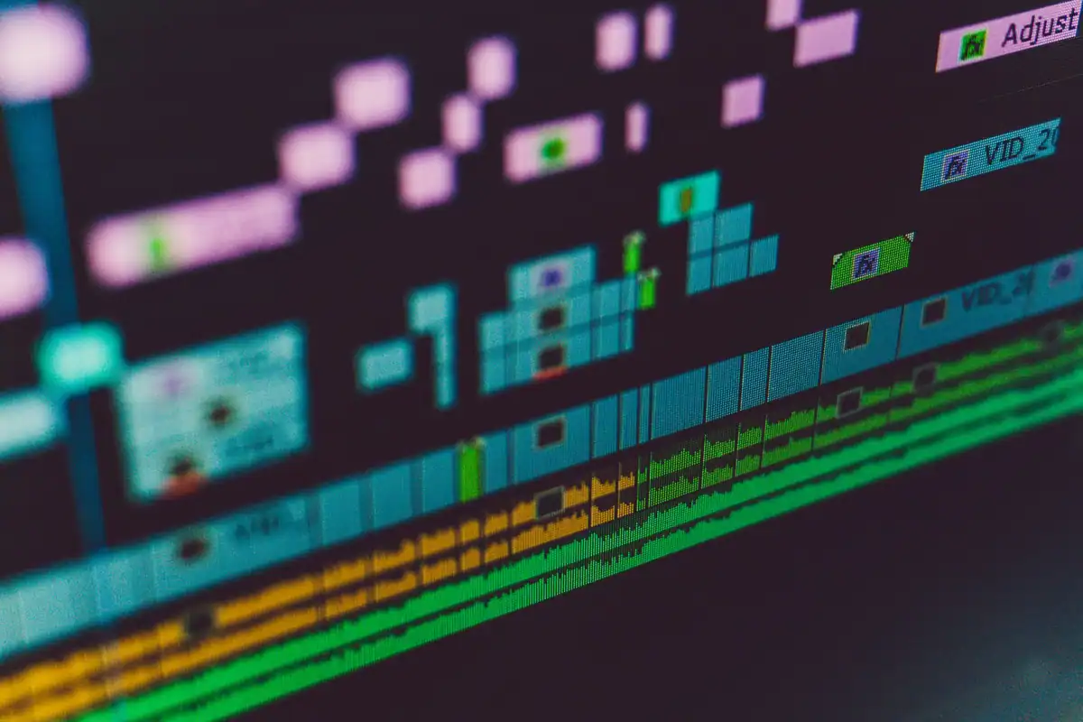 Cronologia unui program de montaj video, cu pistele colorate afișate pe monitor