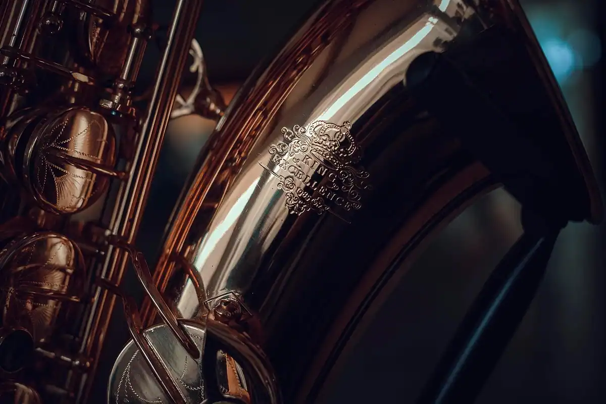 Saxofon auriu fotografiat de aproape, cu clapele și corpul instrumentului strălucind